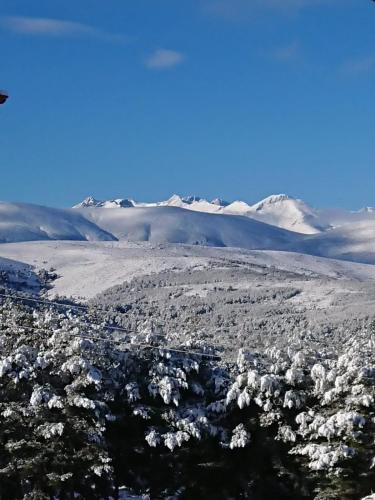 an aerial view of a city with snow covered mountains at Artesano I y III in Navarredonda de Gredos