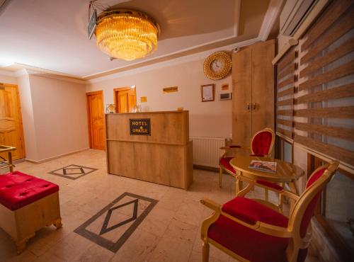 Hotel Orkide في إسطنبول: غرفة معيشة مع طاولة وكراسي وطاولة وغرفة
