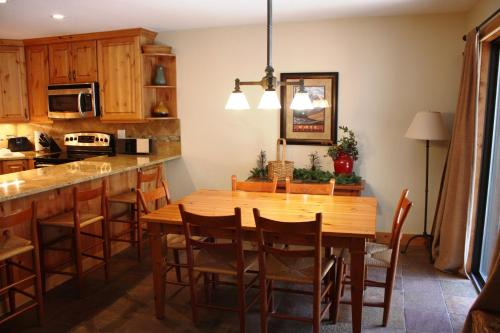 a kitchen with a wooden table and a dining room at Vail Racquet Club Mountain Resort in Vail