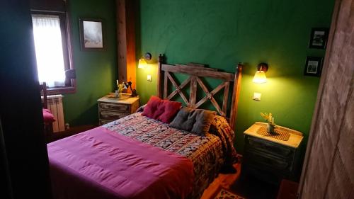 a bedroom with green walls and a large bed at Artesano II in Navarredonda de Gredos