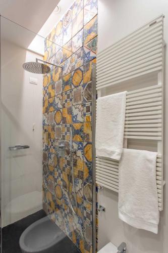 a bathroom with a shower with a mosaic tile wall at Accademia 39 in Sorrento