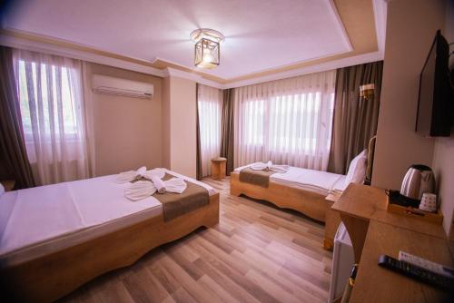 a hotel room with two beds and a television at Hotel Orkide in Istanbul