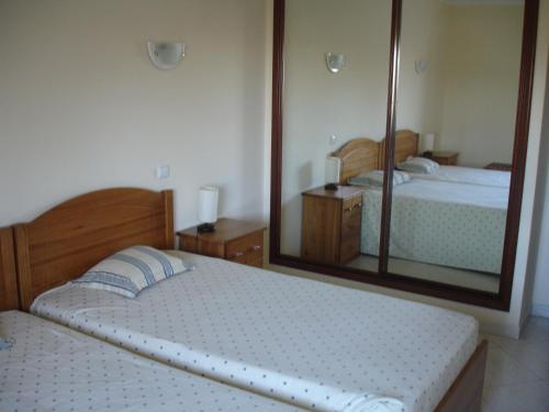 アルヴォルにあるVila Marachique lt 6 108のベッドルーム1室(ベッド2台、大きな鏡付)