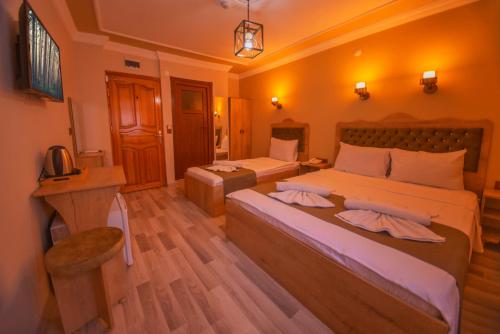 a hotel room with two beds and a desk at Hotel Orkide in Istanbul