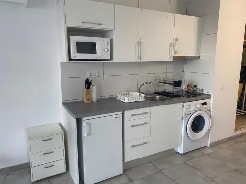una cucina con lavatrice e forno a microonde di Nice Studio in Siesta 2 in Puerto Alcudia 8 a Alcudia