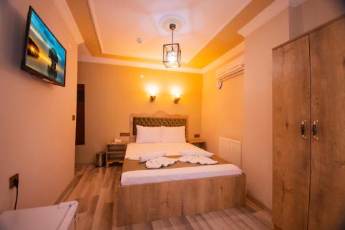 a bedroom with a bed and a tv on the wall at Hotel Orkide in Istanbul
