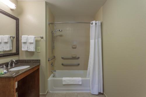 a bathroom with a shower and a tub and a sink at Staybridge Suites North Brunswick, an IHG Hotel in North Brunswick