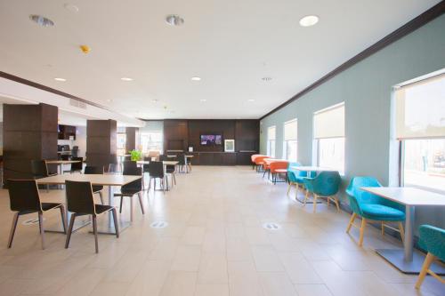 Un comedor con mesas y sillas en un edificio. en Holiday Inn & Suites Spring - The Woodlands, en Spring