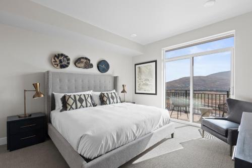 Habitación blanca con cama y balcón. en Black Rock Mountain Resort en Park City