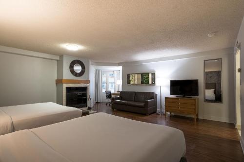 a hotel room with two beds and a flat screen tv at Hotel Chateau Bromont in Bromont