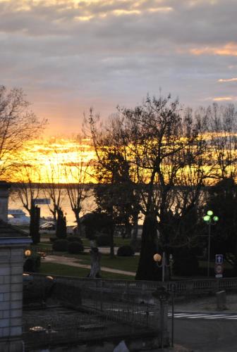 a sunset over the water with trees in a park at AUBERGE DU PORCHE in Blaye
