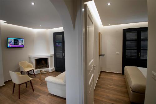 a bedroom with a bed and a living room with a fireplace at Villa Margarita Suites in Hersonissos