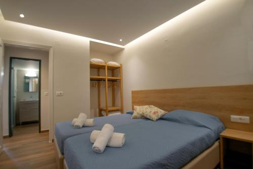a bedroom with a blue bed with two white towels at Villa Margarita Suites in Hersonissos