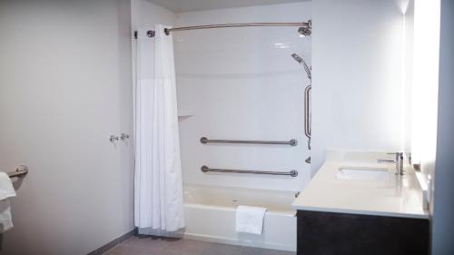 a white bathroom with a shower and a sink at Staybridge Suites Auburn Hills, an IHG Hotel in Auburn Hills