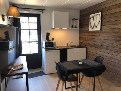 a small kitchen with a table and chairs in a room at Le petit studio de l'espace bien être in Libin