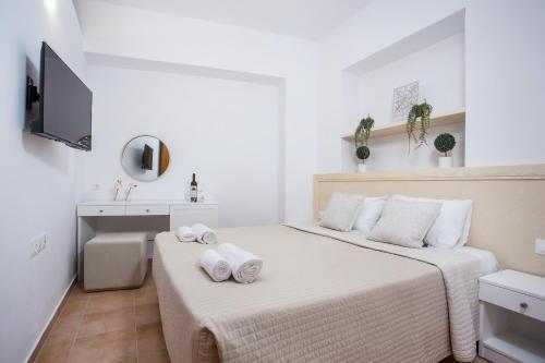 two beds in a small white room with a sink at Kamara Antica Apartments in Rhodes Town
