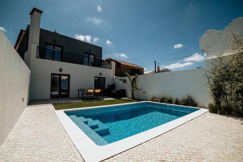 a swimming pool in front of a house at Casa do Coreto, Paço, São Bartolomeu dos Galegos in Paço