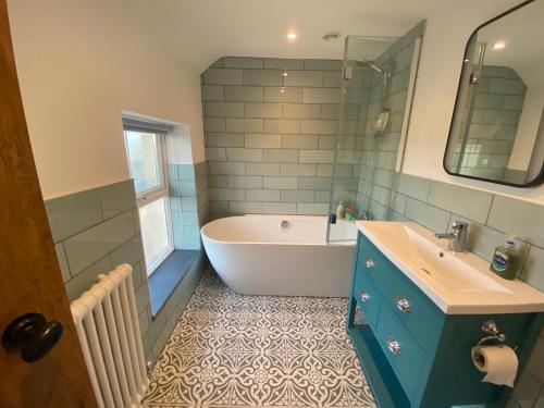 a bathroom with a tub and a sink and a bath tub at Little Hilton Farm in Haverfordwest