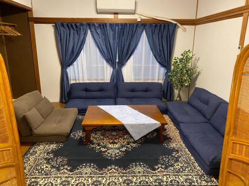a living room with a blue couch and a table at Ise Toyohama Villa - Vacation STAY 11133 in Ise
