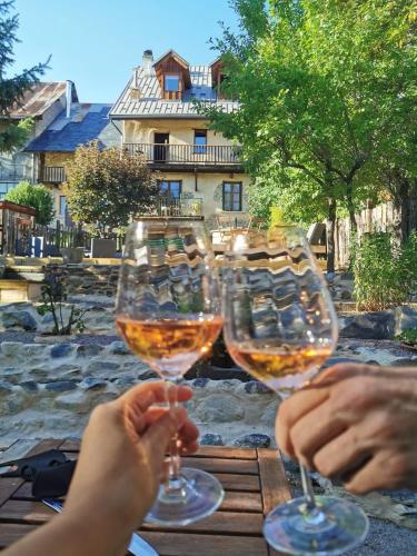 2 personnes tenant des verres de vin sur une table dans l'établissement Chez Bear, à Briançon