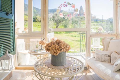 a living room with a table with a vase of flowers at La Casa Di Menny Maison de Campagne in Moneglia