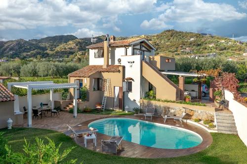 una villa con piscina di fronte a una casa di Villa Alcantara a Graniti