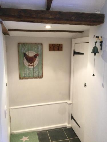 un pasillo con una puerta y una pintura en la pared en The Byre at Heartwood, en Ticehurst