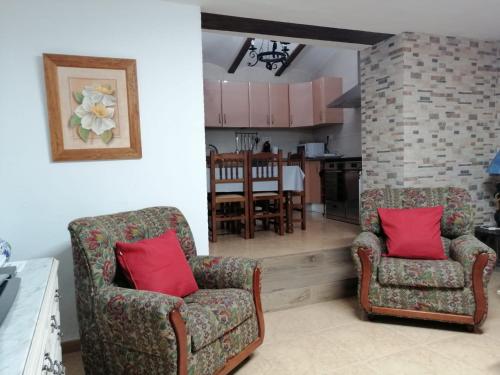 two chairs with red pillows in a living room at Casa Rural Casa La Abuela in Belmonte