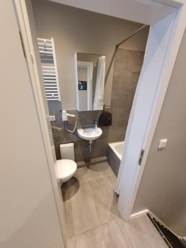 een badkamer met een toilet, een wastafel en een bad bij Stadt Apartments Solingen in Solingen