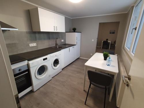 eine Küche mit einer Waschmaschine, einem Trockner und einem Tisch in der Unterkunft Stadt Apartments Solingen in Solingen