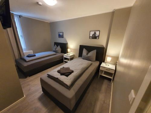 een kleine slaapkamer met 2 bedden en een raam bij Stadt Apartments Solingen in Solingen