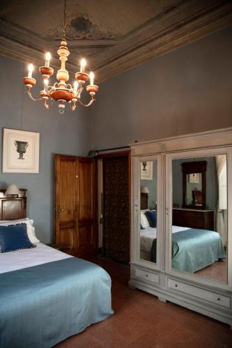 a bedroom with two beds and a chandelier at Hotel Palazzo Guadagni in Florence