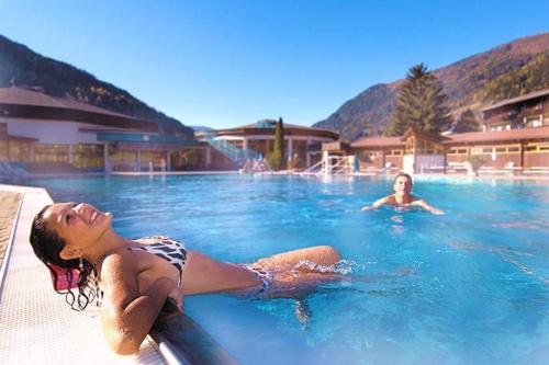 two women laying in a swimming pool at Apartment Ossiachersee Treffen in Afritz