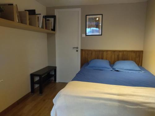 1 dormitorio con cama, mesa y puerta en Aurillac meuble de tourisme, en Aurillac