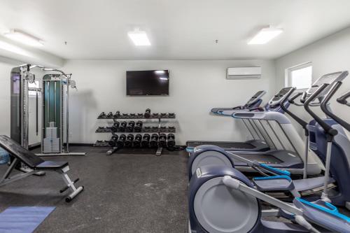 a gym with rows of cardio equipment and a flat screen tv at Sunny Cozy Condo in St. George