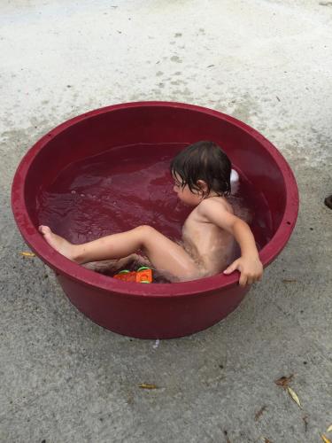 a young boy sitting in a red bucket of water at B&B Panta Rei in Cicerale