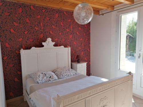 um quarto com uma cama branca e papel de parede vermelho em Chambre avec tout le confort d'un appartement em Villeneuve-lès-Avignon