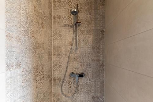 a shower with a shower head in a bathroom at Pósteleki Vendégház-Nyugalom Szigetei in Gyula