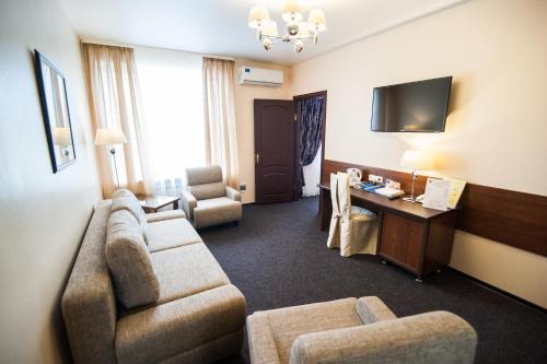 a living room with a couch and chairs and a desk at Hotel Slavyanskaya in Tambov