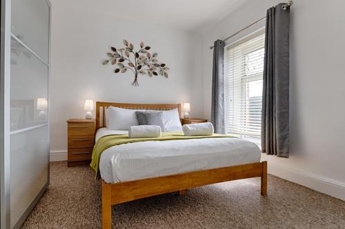 a bedroom with a large bed and a window at Work Stay - Parking - 4BRM - Spacious in Swansea