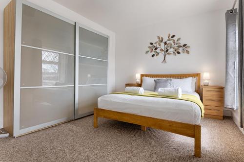 a bedroom with a bed and a glass door at Work Stay - Parking - 4BRM - Spacious in Swansea