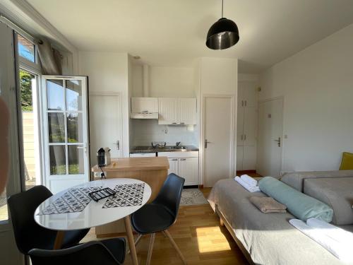 a living room with a table and a couch at Résidence Le Roc Fleuri in Saint Malo