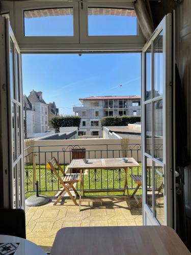 un patio avec une table et des chaises sur un balcon dans l'établissement Résidence Le Roc Fleuri, à Saint-Malo