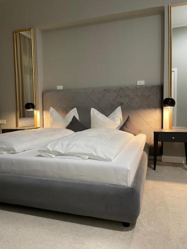 a large bed with white sheets and pillows at Villa Ljiljana in Vinkovci