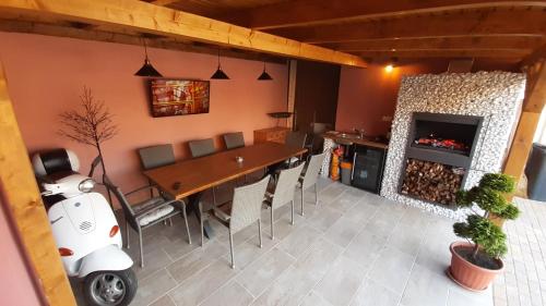 a dining room with a table and a fireplace at Álom Apartman in Hajdúszoboszló