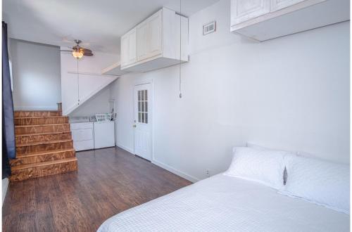 a white bedroom with a bed and a staircase at Tobin Hill 3-2 Apt 5minDT 2min Pearl and St Marys in San Antonio