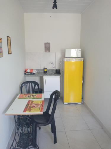 a kitchen with a table and two chairs and a yellow refrigerator at Loft agradável em João Pessoa, PB in João Pessoa