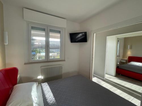 a bedroom with a bed and a red couch and a window at Il Parco di Yuki (3) in Ancona