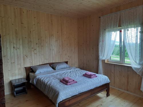 een slaapkamer met een bed in een houten kamer bij Омріяні Карпати in Smozhe