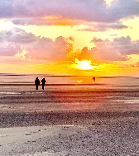two people walking on the beach at sunset at Beach Snug in Lytham St Annes